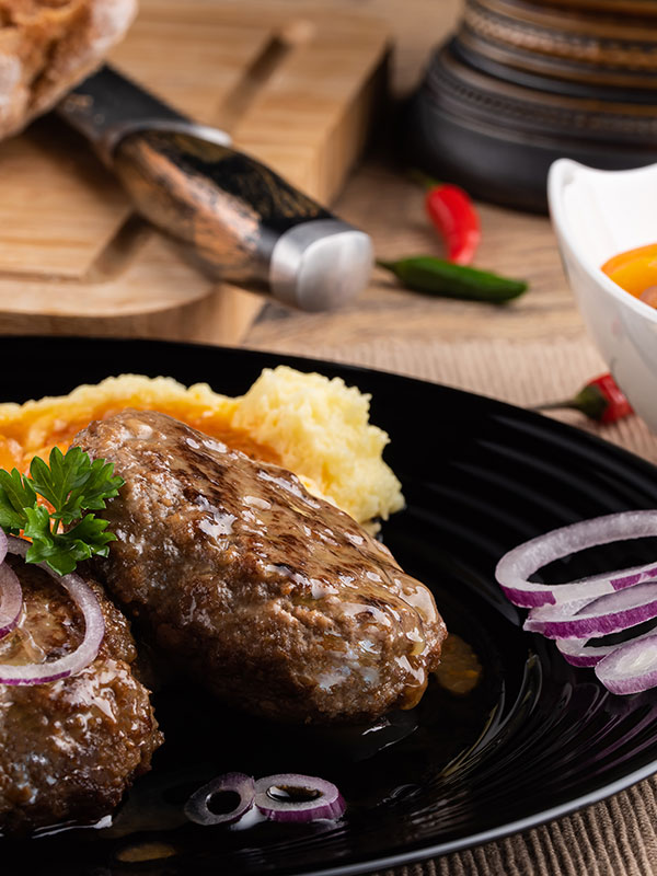Ein fertig angerichteter Teller mit Fleisch und Beilagen.