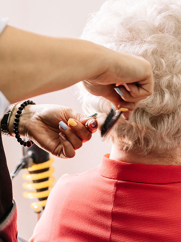 Eine Bewohnerin bekommt im hauseigenen Salon die Haare geschnitten.